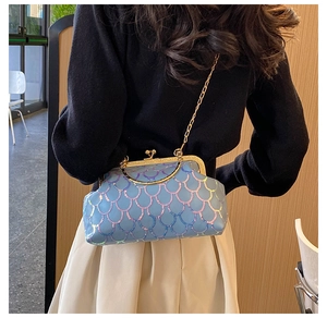 Dettaglio della borsa blu con paillettes a scaglie, chiusura dorata e tracolla a catena