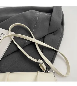 Détail du sac à bandoulière en cuir froncé beige avec boucle en métal argenté réglable