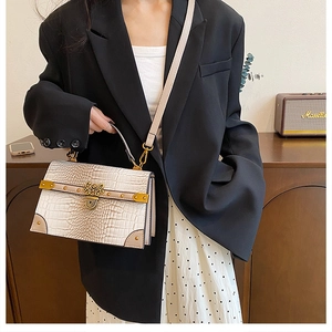 Dettaglio borsa beige con motivo a coccodrillo e fibbia in metallo dorato vintage