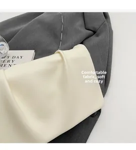 Gros plan sur un sac à main froncé blanc crème en similicuir souple au design minimaliste