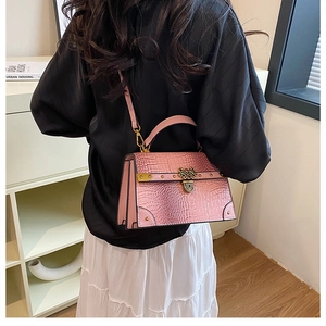 Dettaglio della trama a coccodrillo rosa e della chiusura in metallo vintage della borsa