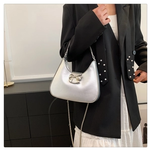 Gros plan du sac demi-lune argenté avec boucle nœud et détails de la chaîne
