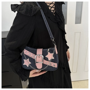 Close-up of Y2K denim shoulder bag featuring pink star patches and metallic chain detail