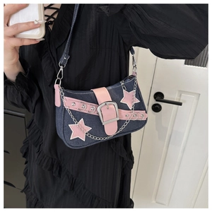 Detail of Y2K denim shoulder bag with pink star patches and metallic chain accessory