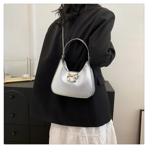 Borsa hobo argento con fiocco decorativo indossata a spalla in un set moderno