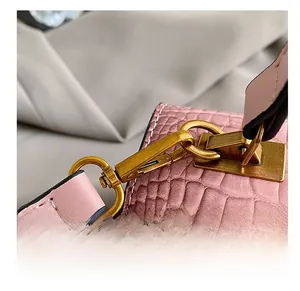Dettaglio borsa in pelle rosa coccodrillo con ganci metallici dorati stile vintage