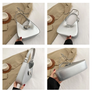 Detail view of silver metallic crescent bag with bow decoration and chain strap
