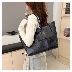 Macro detail of high-quality black crocodile-effect texture on spacious tote bag