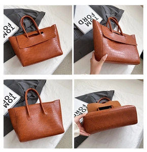 Macro view of caramel brown crocodile embossed tote bag with flap and sturdy handles