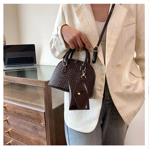 Detail of dark brown crocodile pattern PU leather shell bag with mini envelope pouch strap