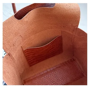 Interior detail of large tote bag showing suede lining and crocodile pattern inner pocket