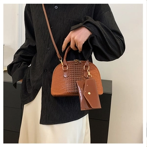 Brown crocodile embossed shell bag detail with matching mini envelope pouch and gold hardware