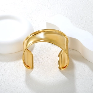 Vue détaillée d'un bracelet manchette large plaqué or 18 carats sur supports géométriques