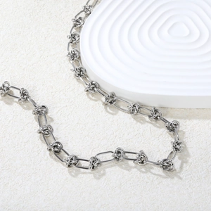 Minimalist silver stainless steel knotted link chain necklace for women on white stand