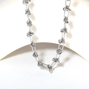 Macro detail of silver knot links on minimalist industrial style chain necklace