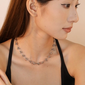 Minimalist stainless steel knot link chain necklace on female model neck side view