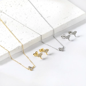 Vue détaillée du collier pendentif cœur couronne et des boucles d'oreilles sur pierre