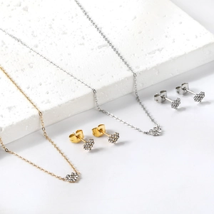 Détails des parures de bijoux coeur en or et argent avec strass sur marbre blanc