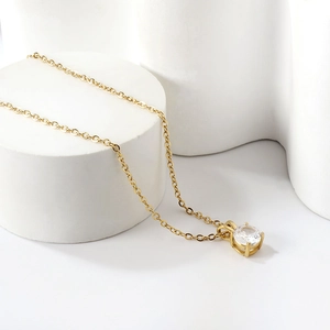 Detailed close-up of a 18K gold-plated O-chain with a sparkling round diamond pendant