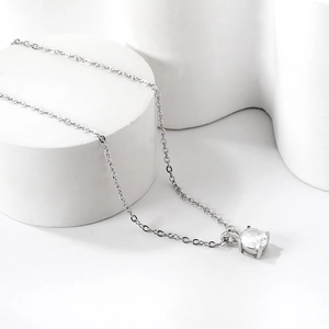 Detailed close-up of a four-prong set sparkling round zircon pendant on a silver O-chain