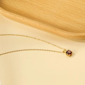 Detail of red round zircon pendant with 18K gold plated stainless steel chain