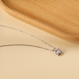 Close-up of 18K gold plated necklace featuring a round lavender zircon pendant