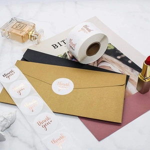 White and rose gold Thank You stickers on marble background with elegant gift envelopes