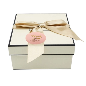 Adesivo Thank You rosa oro su confezione regalo color crema con nastro di raso champagne