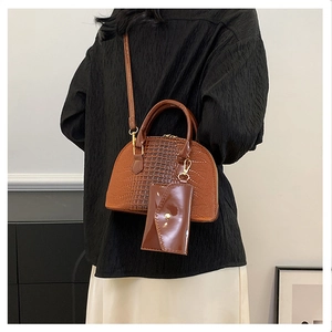 Close-up of brown crocodile pattern shell bag with a matching detachable coin purse
