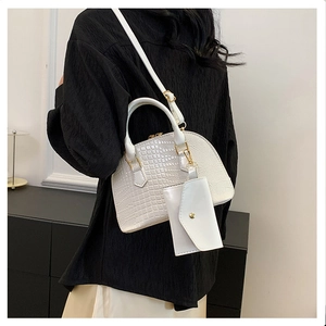 White crocodile pattern shell bag with mini coin purse shown on a model