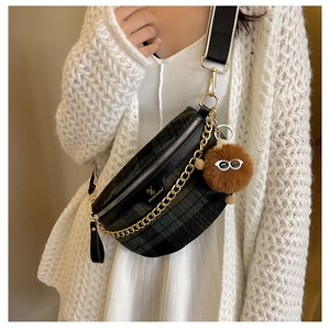 Detail of retro plaid chest bag with golden chain and funny plush monster charm
