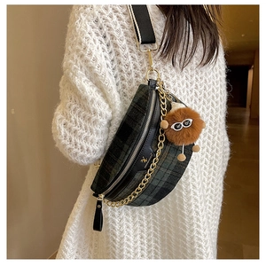 Detail of vintage plaid chest bag with golden chain and plush bear charm accent