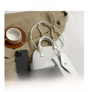 Detail of white crocodile pattern shell bag with mini purse and gold metal hooks