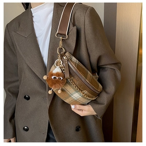 Detail of plaid crossbody chest bag with decorative chain and plush doll charm accessory