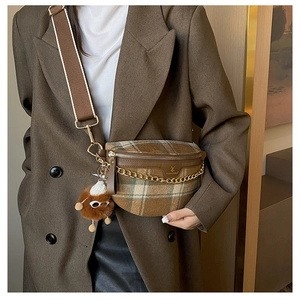 Brown plaid crossbody bag with metal chain detail and plush bear charm on model