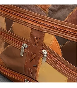 Detail of vintage soft leather bag with multi-color patchwork and metal zippers