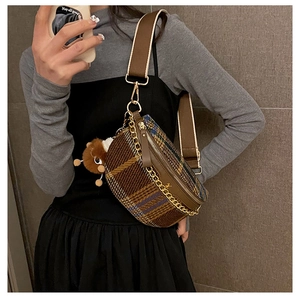 Close-up of vintage plaid chest bag with golden chain and cute brown plush bear charm