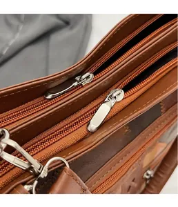 Detailed close-up of premium leather tote bag zippers with three silver polished pulls