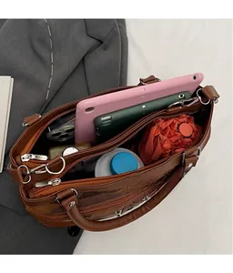 Internal view of brown leather handbag with multiple compartments for tablet and essentials
