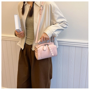 Pink mini Boston bag with lychee texture and silver zippers shown on a cross-body strap