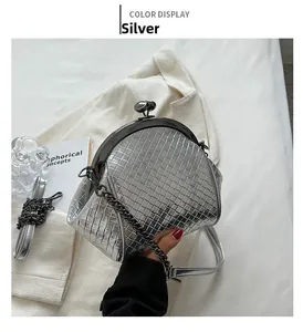 Detail of silver woven shell bag with metallic chain and sphere clasp over a magazine