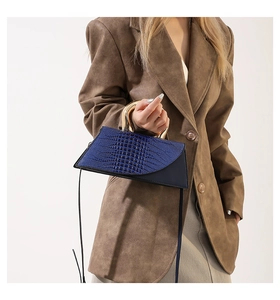 Blue crocodile pattern bag with gold metal handle styled with a brown suit for women