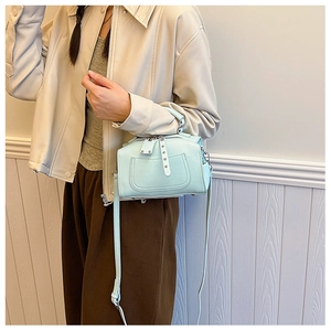 Close-up of mint blue boston bag with pebble leather texture and silver rivets details