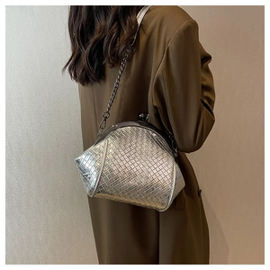 Silver woven texture on a shell-shaped crossbody bag with a metal chain strap