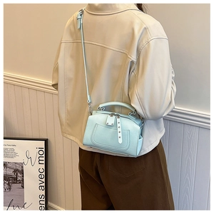 Detailed view of mint blue mini boston bag with silver studs and adjustable strap
