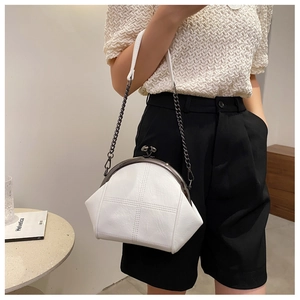 Detailed side view of white quilted leather shell bag with vintage metal clasp and chain