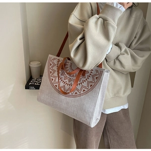 Detail of a large Japanese-style tote bag with geometric sun print and brown leather straps