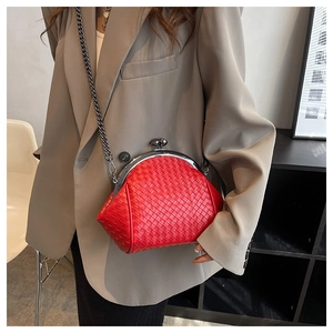 Detail of red woven leather clutch with kiss-lock clasp and dark metal chain strap