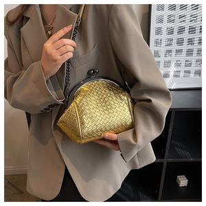 Close-up of golden woven shell clutch bag with metallic frame and chain strap