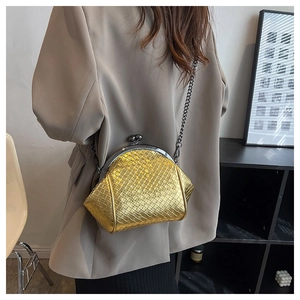 Detail view of woven gold shell bag featuring vintage metal clasp and chain strap